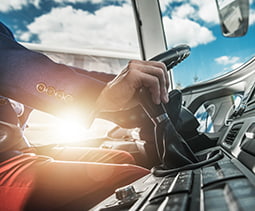 A bus driver at the wheel of a charter bus